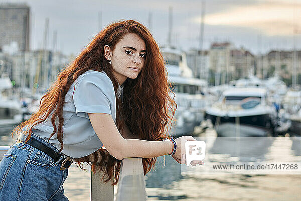 Portrait of a young redhead woman in a seaport of a city