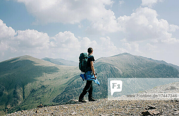 man at the summit of Snowdonia on a beautiful sunny day in Wales