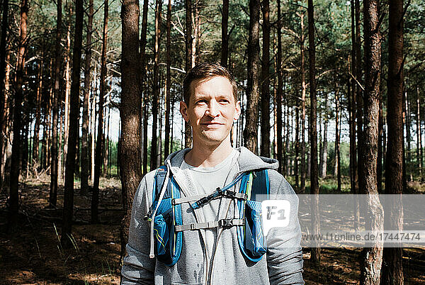 portrait of a man stood in a forest with a running vest on