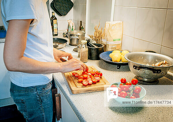 Side view of woman in kitchen while preparing dinner of vegetables