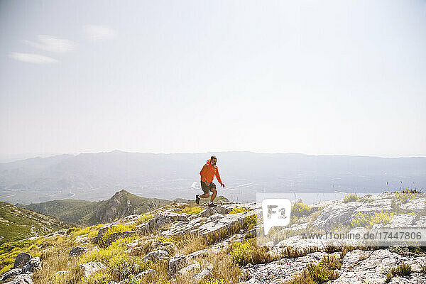 Male hiker running on rocks in mountain