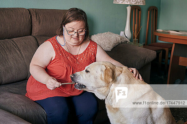 Adult woman with down syndrome has fun with her dog at home