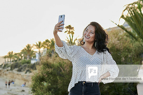 Young Asian woman takes a self-portrait with her phone