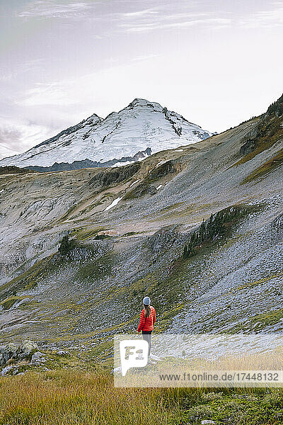 Female In Tights And Red Puffy Jacket Standing In Front Of Mount Baker