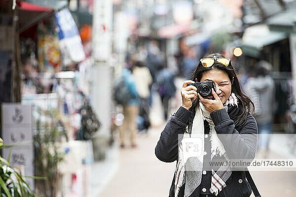 woman taking a picture with digital mirrorless camera in Tokyo