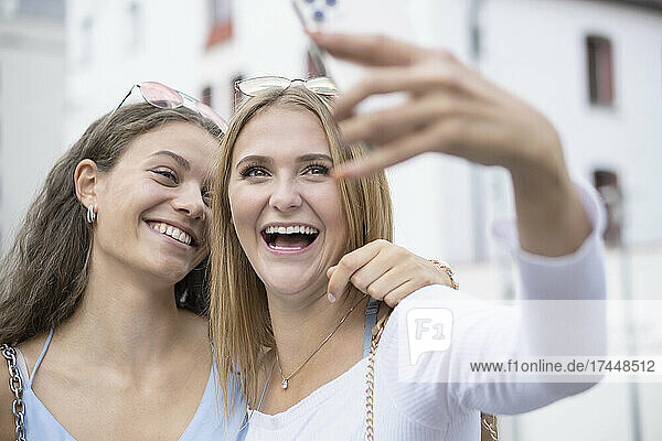 two young women making selfy with mobilephone in surroundings