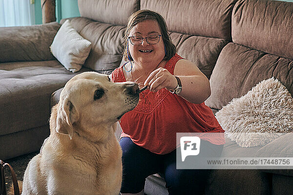 Adult woman with down syndrome has fun with her dog at home