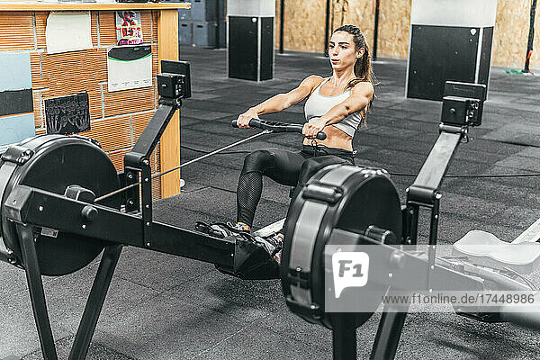 woman on her back doing rowing in the gym  crossfit