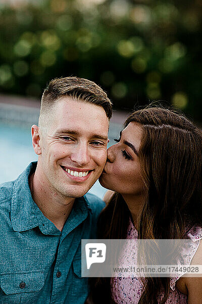 Wife Kissing Smiling Husband on Cheek in San Diego
