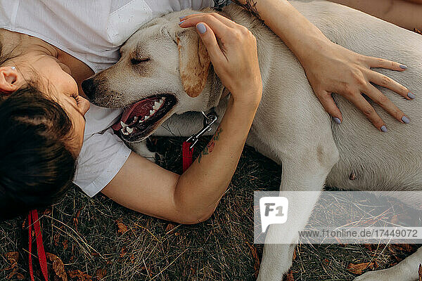 Woman hugging her Labrador outdoors. Lifestyles and pet care concept.