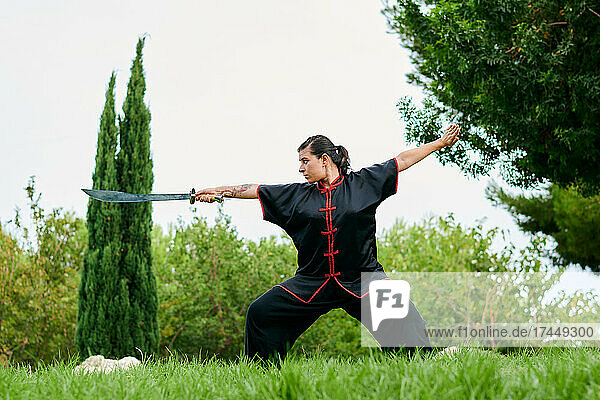 Woman in uniform practicing martial arts with a sword