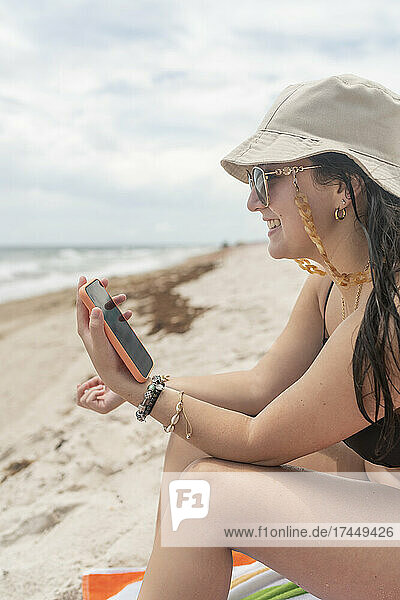 Girl on the beach in a video conferencing session by cell phone