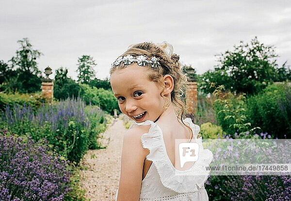 young flower girl smiling at a wedding in a beautiful field of flowers