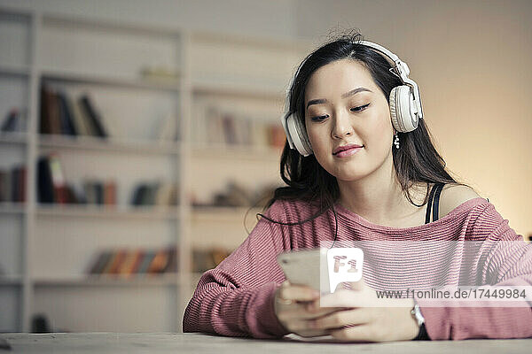 young woman listens to music from smartphone
