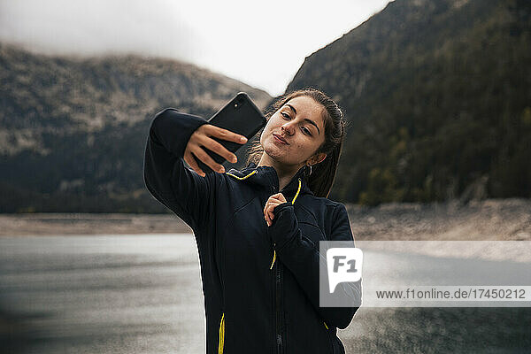 Girl taking a selfie in the mountains with her mobile