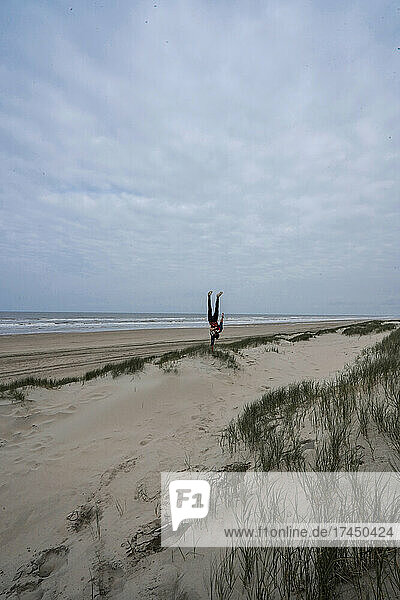 A man doing a Handstand on a beach near the sea  Netherlands  Europe