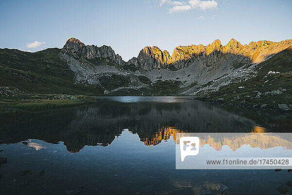 Lake reflection panorama against mountain range at sunset  Pyrenees.