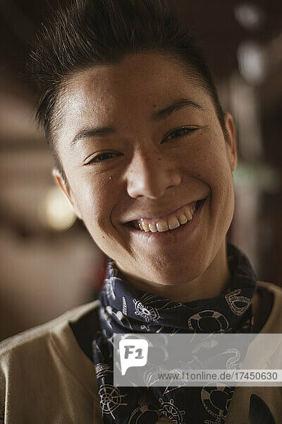 happy smiling queer asian woman inside warm cottage in czech republic