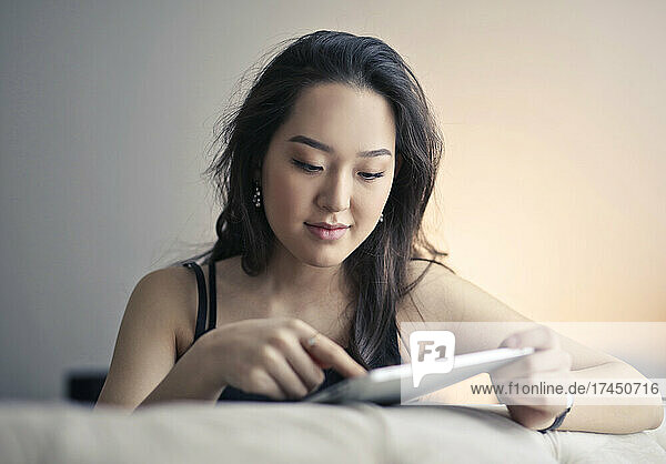 young woman works with a tablet on the sofa