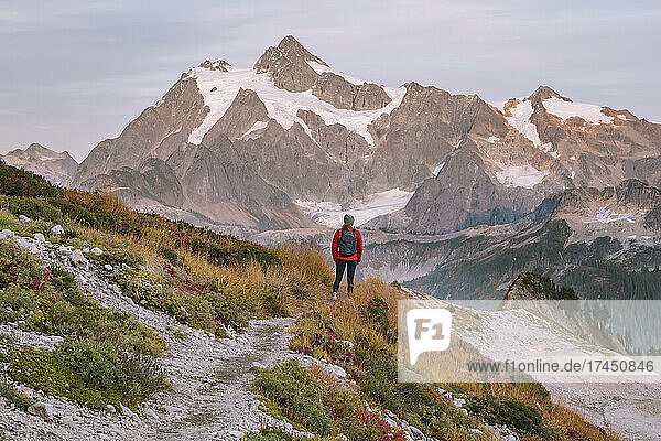 Female With Backpack Standing In Front Of Mount Shuksan