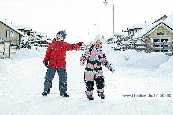 Two children have fun walking at the winter village.