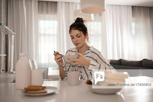 Young woman having breakfast at home