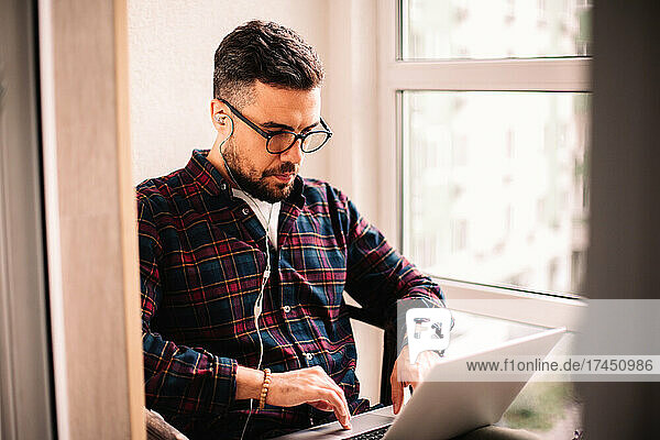 Man using laptop computer while working at home