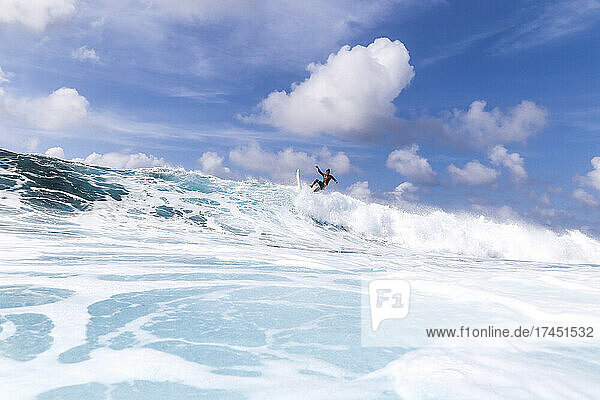 Surfer on a blue wave at sunny day