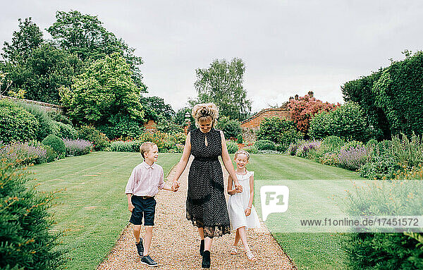 mother and her kids at a wedding walking through a beautiful garden