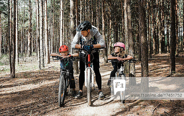 Papa und seine Kinder genießen eine Radtour im Wald