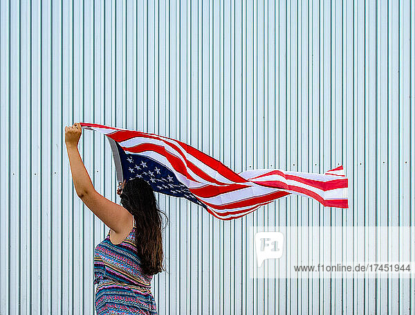 Latin woman waving US flag