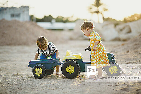 Children playing together with toy tractor