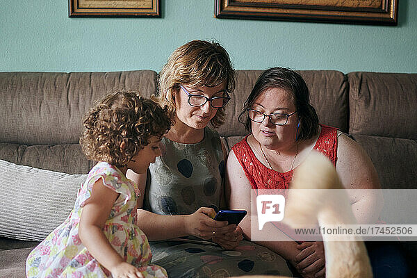 Mother with her daughter and her sister with down syndrome at home