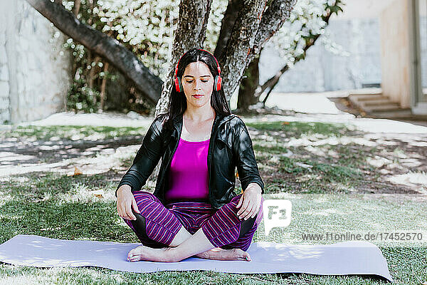 mature Latin woman meditating and practicing yoga at home in Mexico