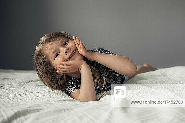 Little cute girl lying on the bed.