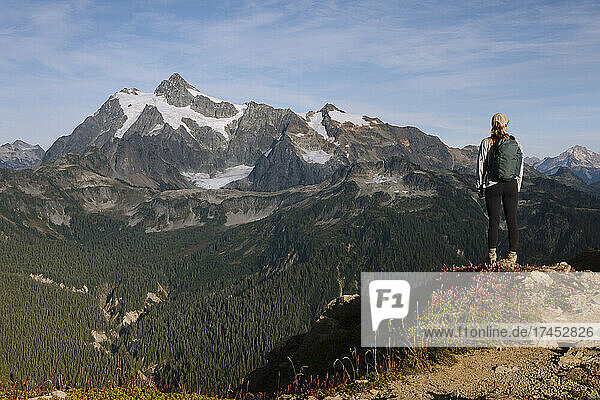 Female Hiker Standing Over A Valley With Mount Shuksan