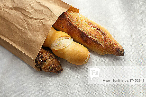 rye  wheat  multigrain baguettes in paper bag on white tablecloth
