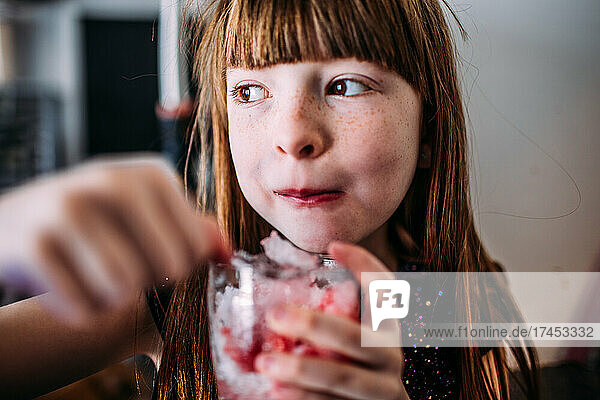 Happy young girl enjoying a home made snow cone