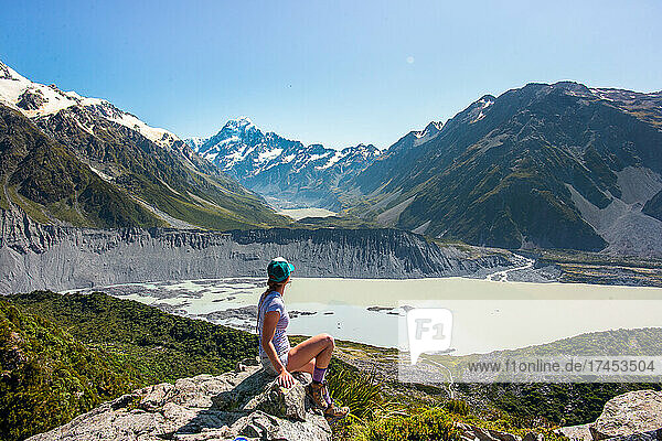 Hiker Girl Sits At Overlook In Mount Cook  New Zealand