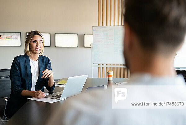 Businesswoman talking with colleague during meeting