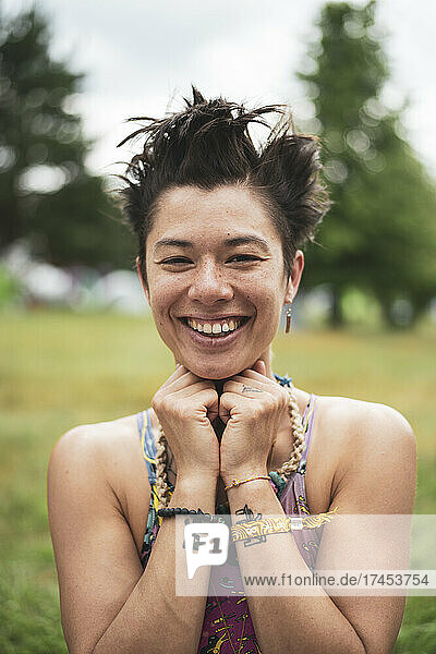 Smiling mixed-race asian woman with fun hair at festival in Poland