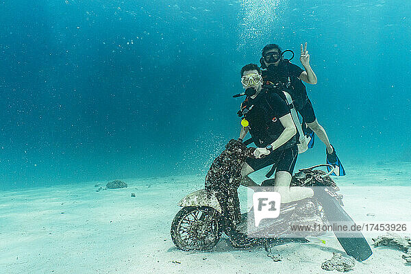 divers posing on motorbike on the ocean floor at Phuket
