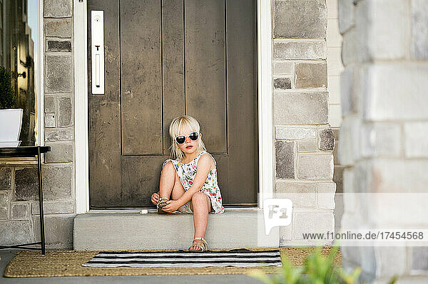 Girl wearing sunglasses on front porch