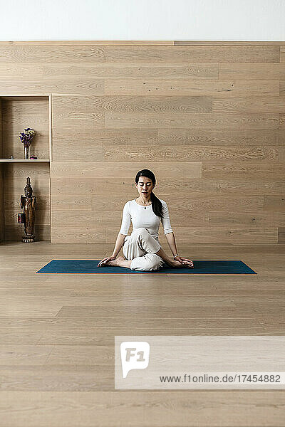 Asian woman practice yoga Gomukhasana or Cow Face pose to meditation