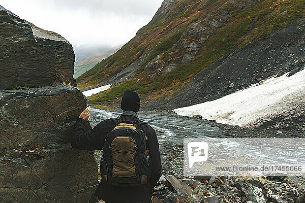 A lone man hikes the boulder fields of Byron Glacier in Alaska