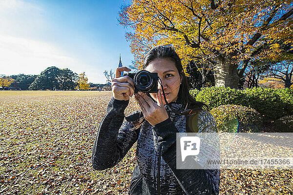 woman taking a picture with digital mirrorless camera at Tokyo gardens