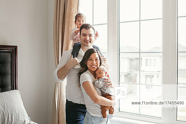 Happy multiracial young family with children at home.