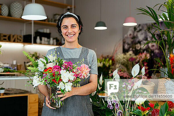 Portrait of a young woman holding a bouquet in a florist
