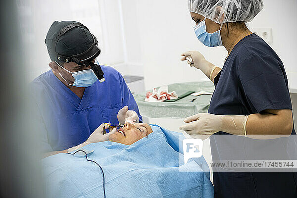 Surgeon sutures the eyelid after plastic surgery operation