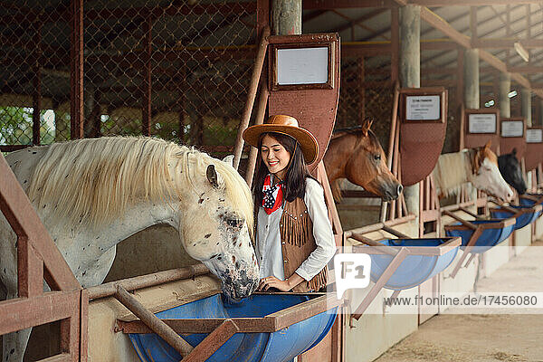 Cowgirl working stables.Concept of retro woman in horse ranch